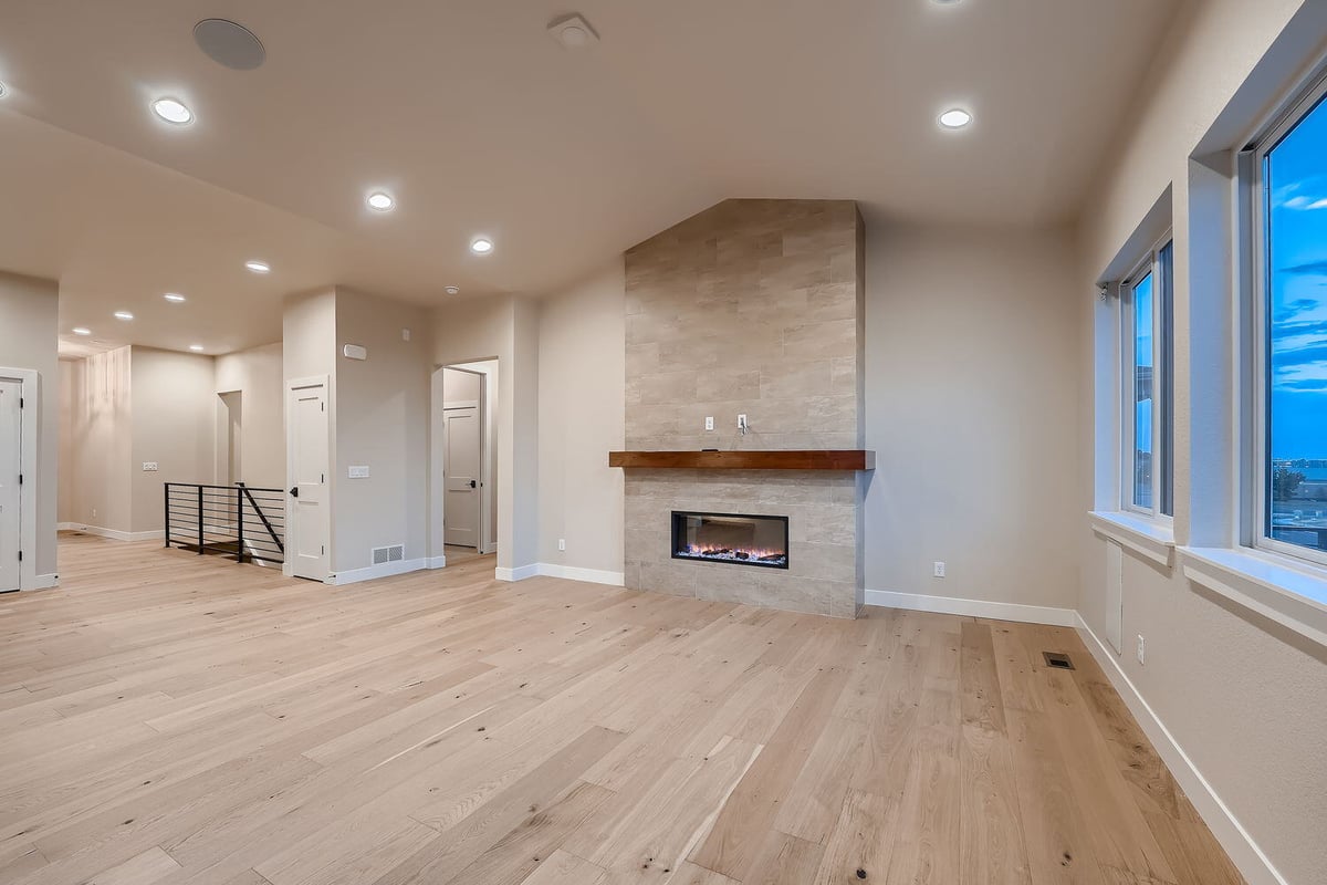 Living room with large windows and a modern fireplace in a Sheffield Homes custom home, Denver, CO