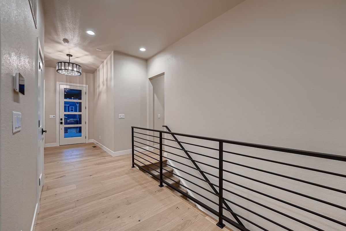 Modern foyer with wood flooring and stylish lighting in a Sheffield Homes custom build, Denver, CO