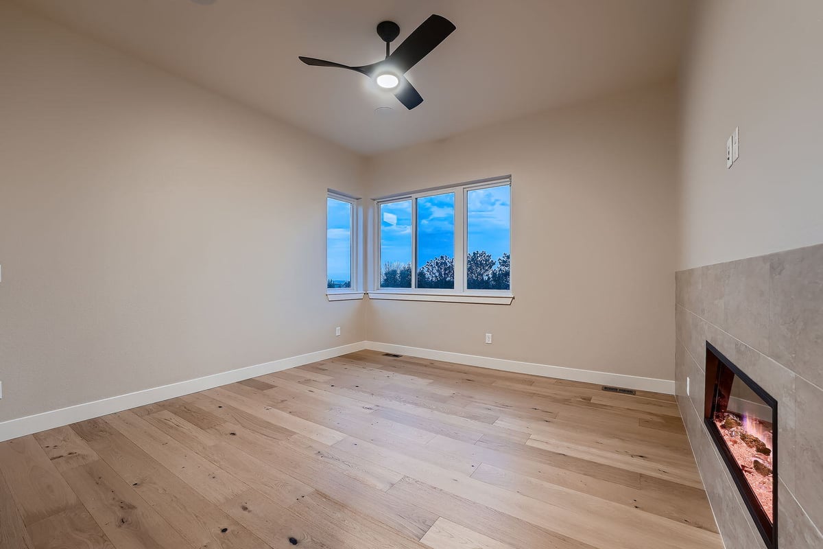 Primary bedroom with large windows and ceiling fan in a custom home by Sheffield Homes, Denver
