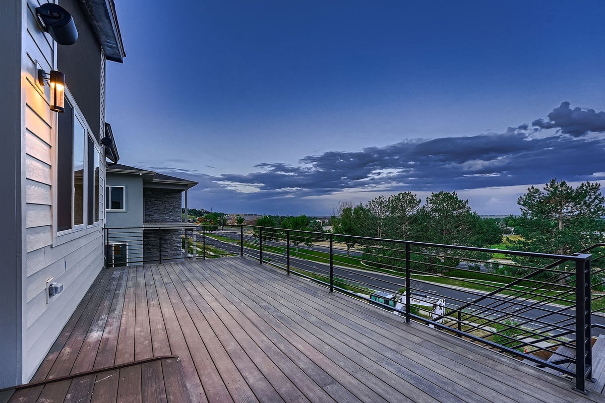 Spacious outdoor deck with railing and scenic view in a custom Denver home by Sheffield Homes