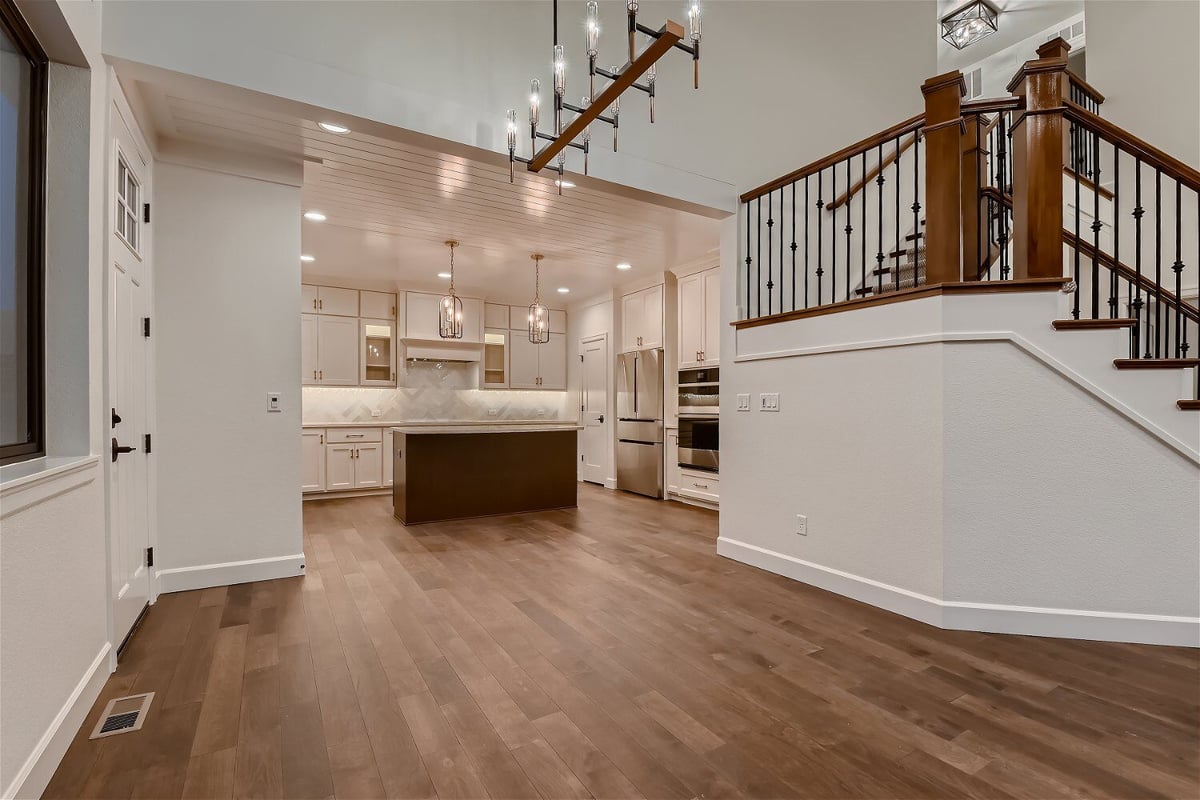 Dining room with ample space and an open kitchen in the corner inside a custom home by Sheffield Homes in Louisville, CO