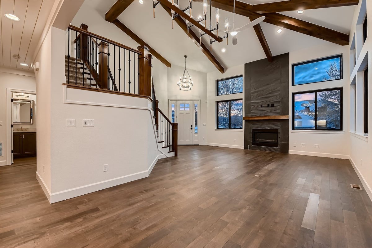 Dining room with wood texture flooring, a foyer, and a corner fireplace in a custom home by Sheffield Homes in Louisville, CO
