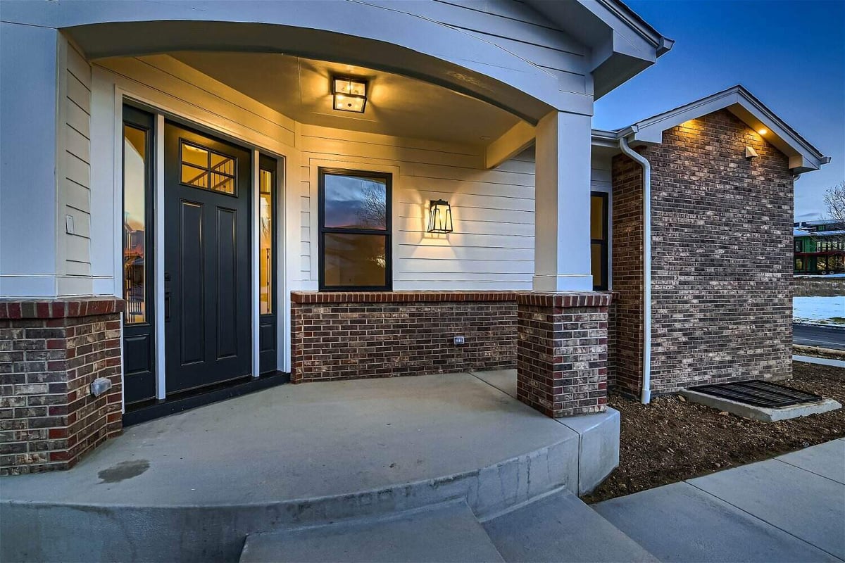 Exterior front entrance of a custom home featuring stone accent borders, built by Sheffield Homes in Louisville, CO