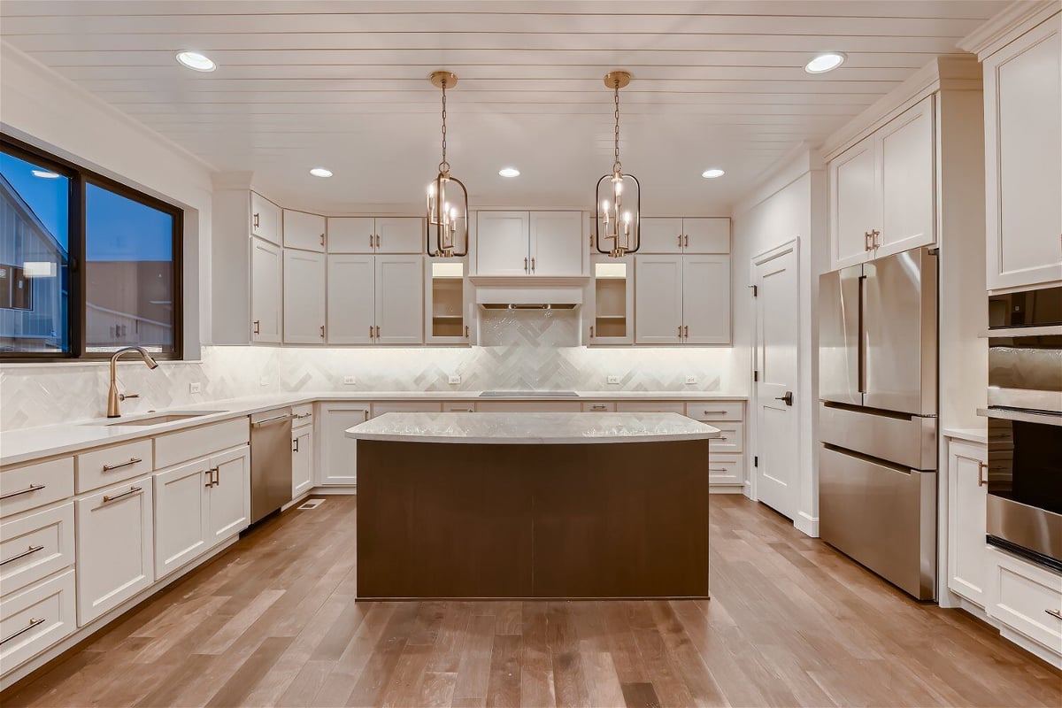 Modern kitchen with a central island, sleek white cabinetry, and clean design in a Sheffield Homes project in Louisville, CO