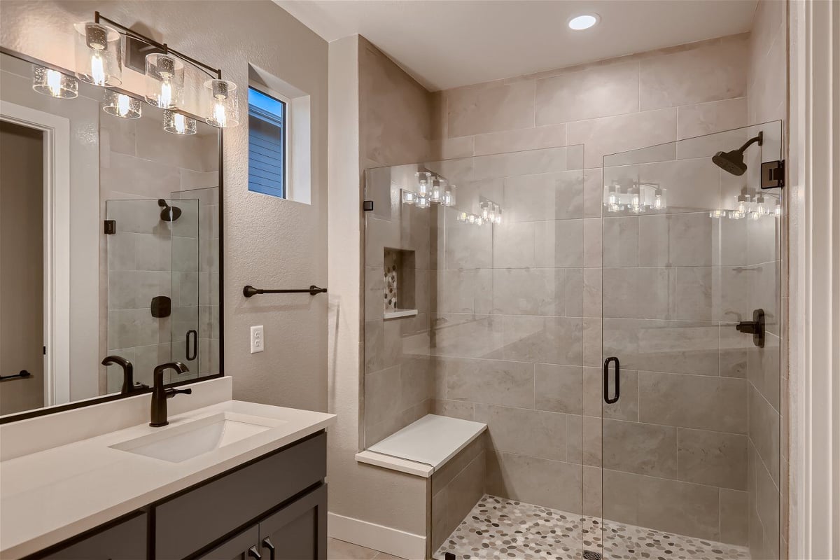 Primary bathroom featuring a vanity with pendant lighting, and a shower area in a Sheffield Homes home in Louisville, CO