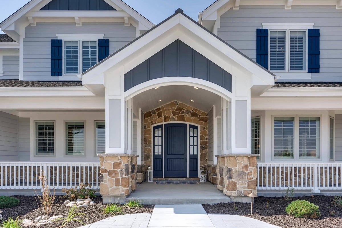 Exterior front entrance of a large custom-designed home with stone columns and wall design by Sheffield Homes in Parker, CO
