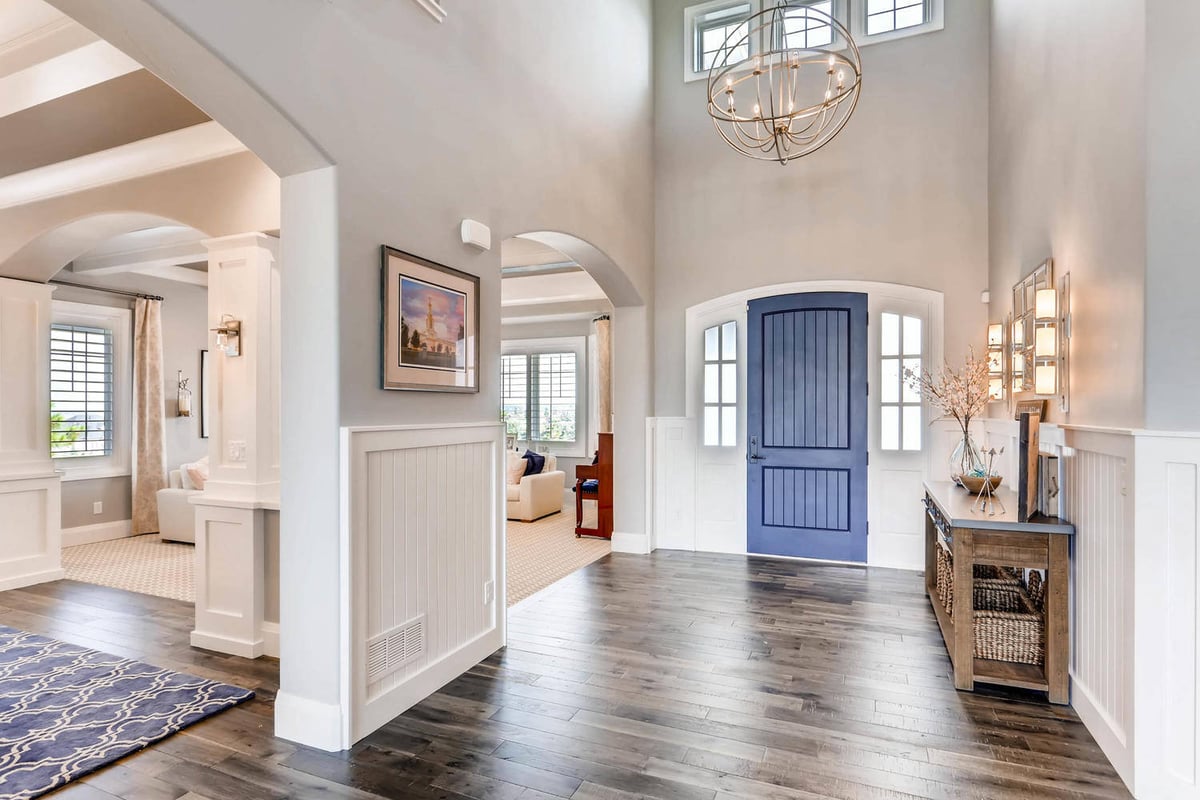 Foyer in a large custom home with elegant lighting fixtures and wood texture flooring by Sheffield Homes in Parker, CO