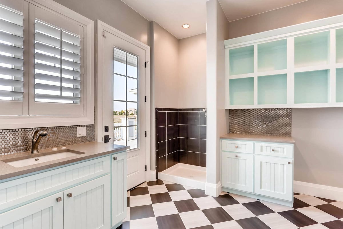 Laundry room with a checked floor design, wash basin, and cabinetry for storage in a Sheffield Homes home in Parker, CO