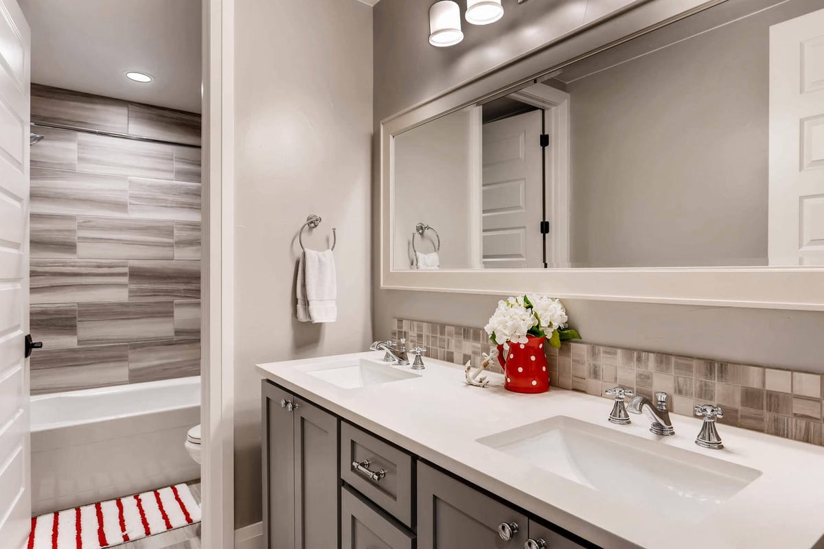 Lower-level premium bathroom with dual vanities and a separate shower room in a Sheffield Homes home in Parker, CO
