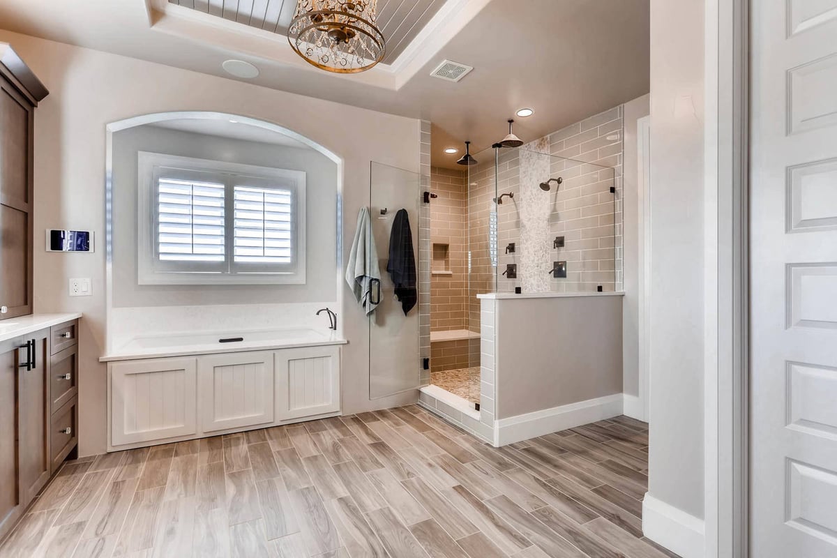 Master bathroom with a glass-enclosed shower, a premium bathtub, and some cabinetry in a Sheffield Homes home in Parker, CO