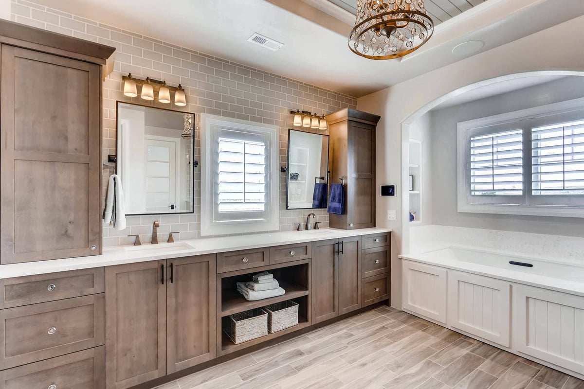 Master bathroom with premium dual vanities and cabinets next to a bathtub in a custom home by Sheffield Homes in Parker, CO