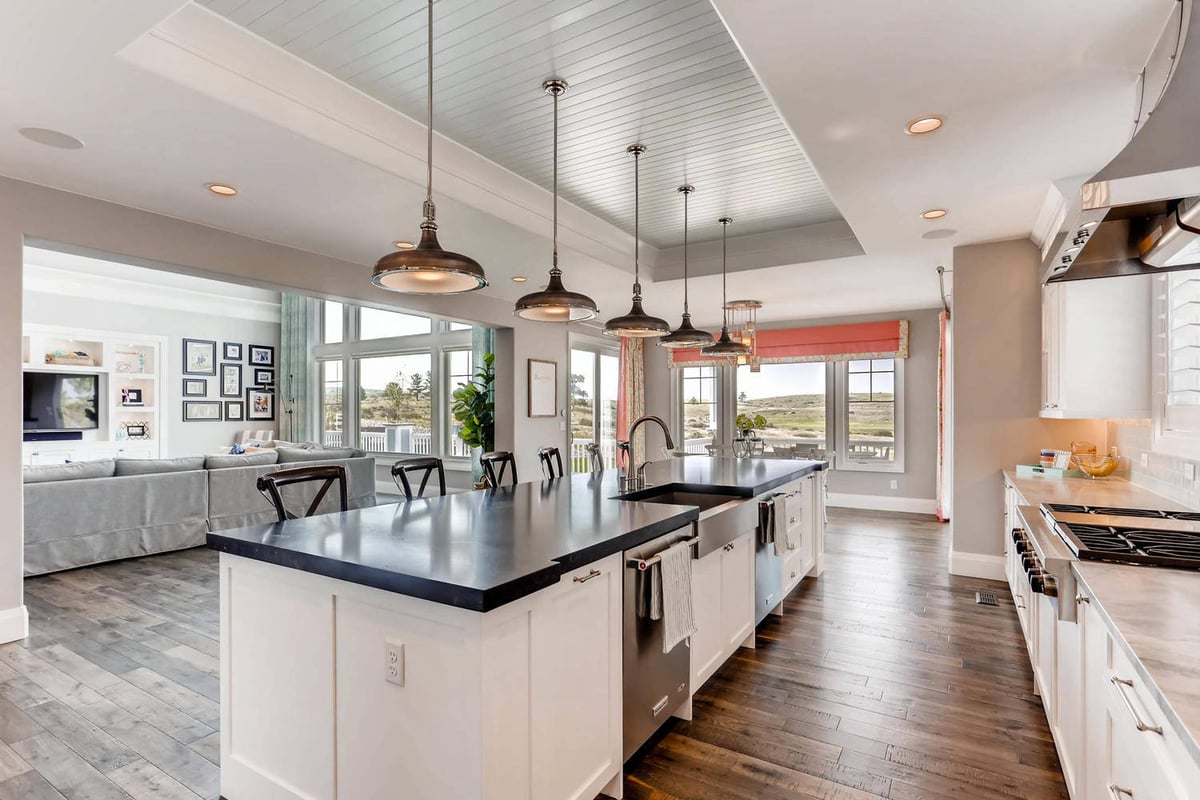 Open-concept kitchen with an island, main counter with stove fixtures, and cabinets in a Sheffield Homes home in Parker, CO