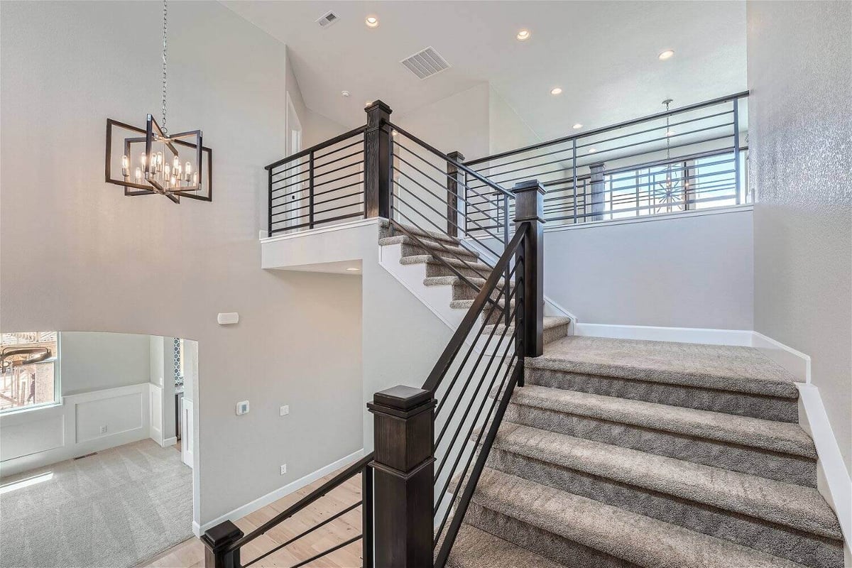 Detailed second-floor stairways with wooden railings and carpeted steps in a Sheffield Homes home in Superior, CO-1