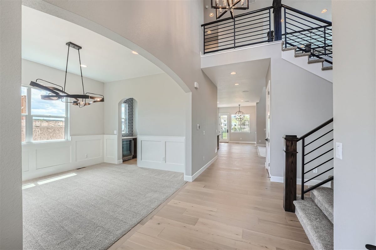 Dining room with carpet flooring and a pendant chandelier, in front of the stairway in a Sheffield Homes home in Superior, CO