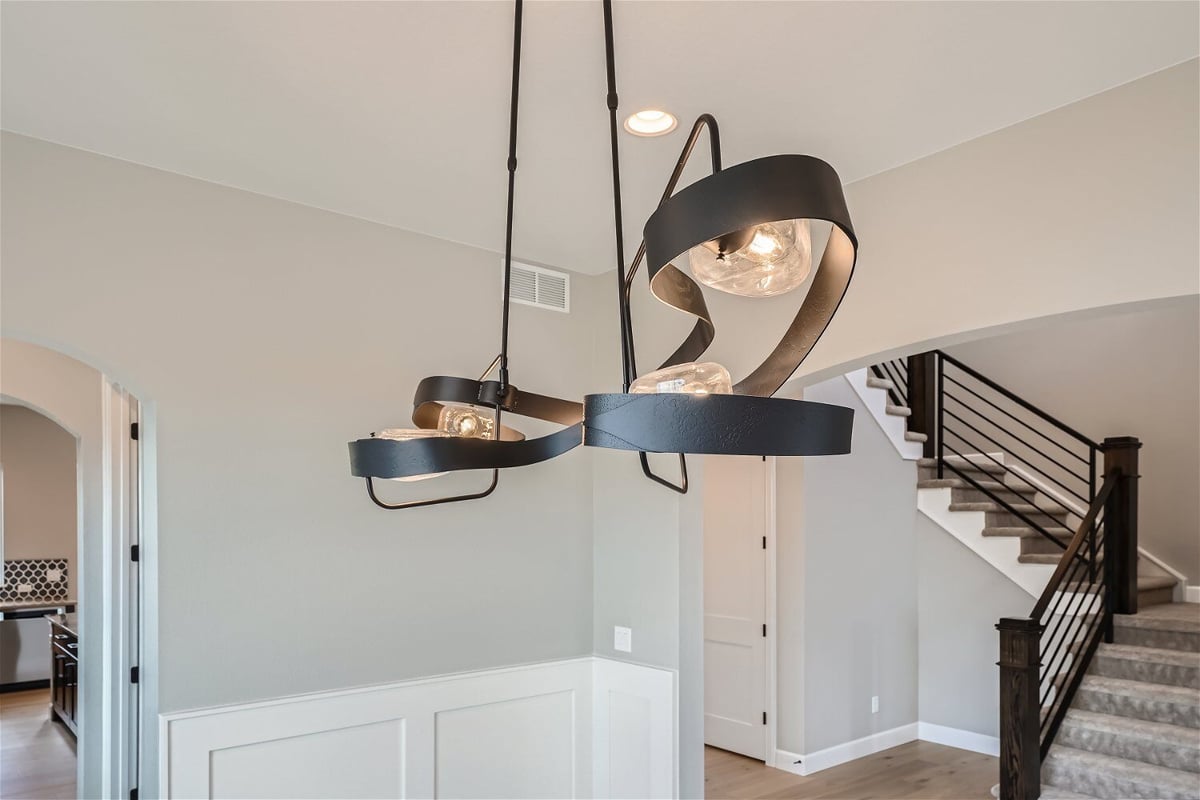 Fancy pendant chandelier detailing with lit-up bulbs in the dining room of a custom home by Sheffield Homes in Superior, CO