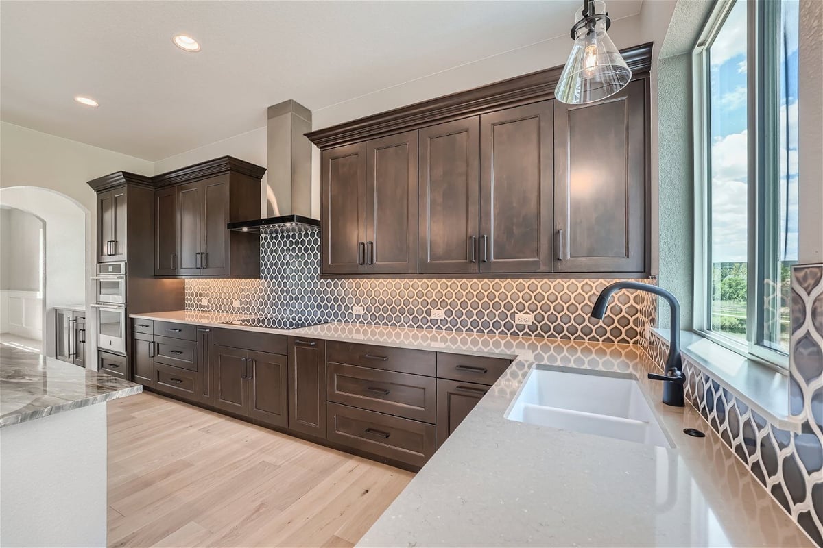 Kitchen sink with a smooth countertop and a faucet, with sunlight coming through in a Sheffield Homes home in Superior, CO