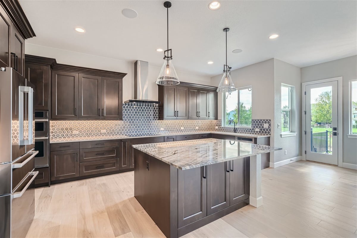 Kitchen with contemporary light fixtures, wooden cabinets, and windows for sunlight in a Sheffield Homes home in Superior, CO