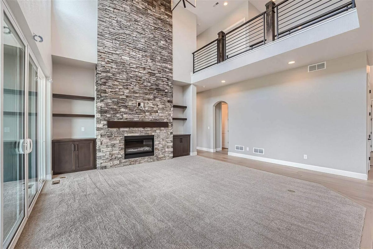Living room with a corner fireplace, cabinetry for storage, and main access doors in a Sheffield Homes home in Superior, CO