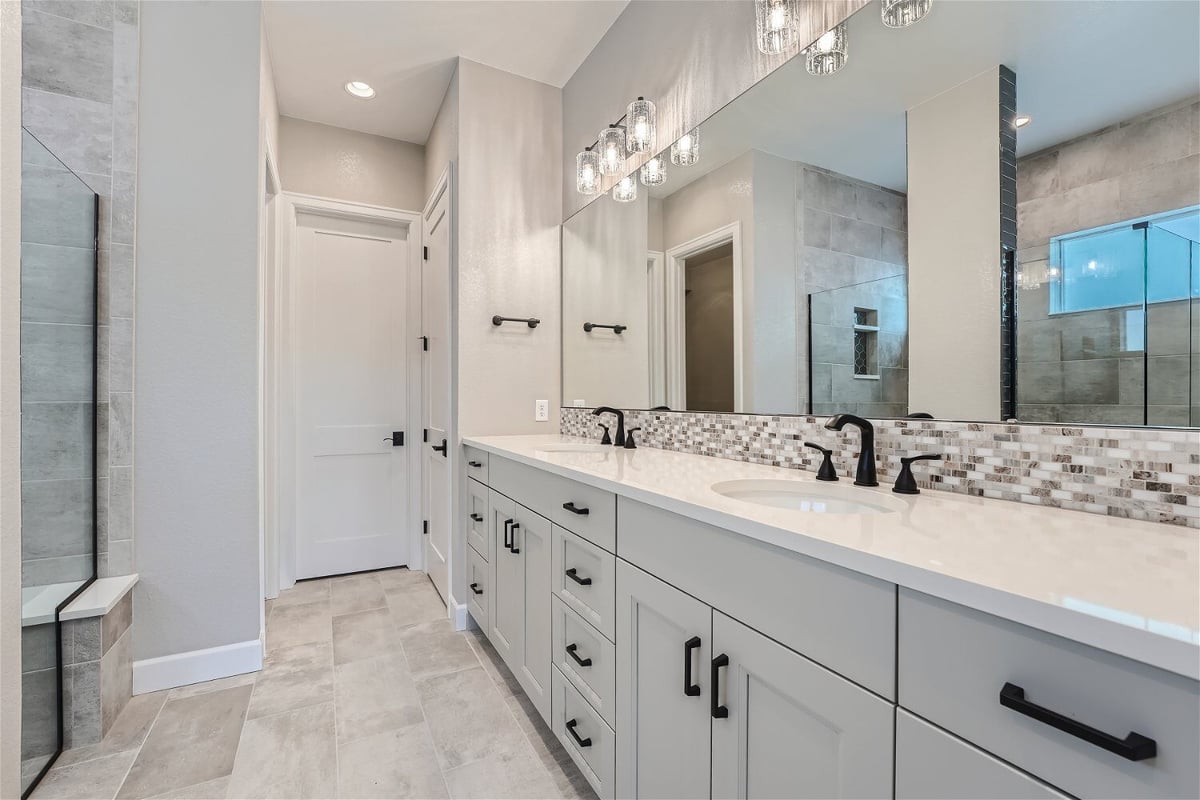 Premium bathroom with elegant lighting, vanities, and a glass-enclosed shower room in a Sheffield Homes home in Superior, CO