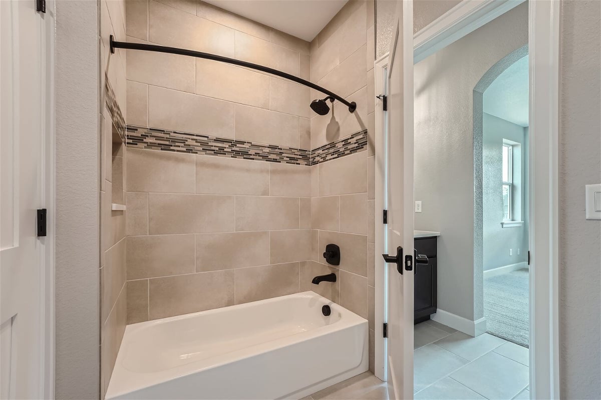 Second-floor Jack and Jill bathroom with a separate shower room and a tub in a Sheffield Homes home in Superior, CO