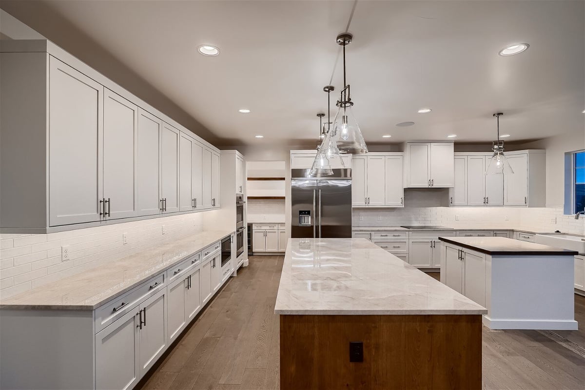 Close-up of a kitchen island with a marble countertop and wooden cabinetry base in a Sheffield Homes home in Superior, CO