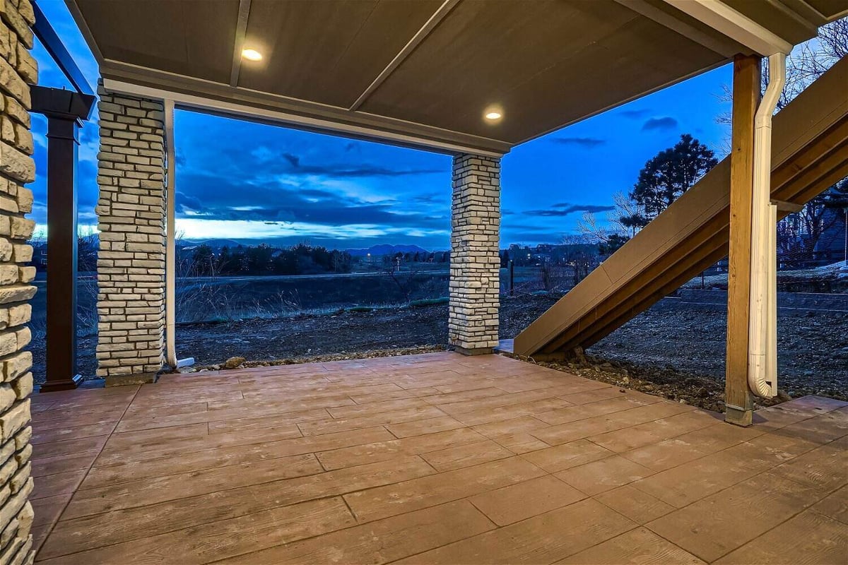 Custom patio with stone accent pillars and wooden beams in a custom home by Sheffield Homes in Superior, CO