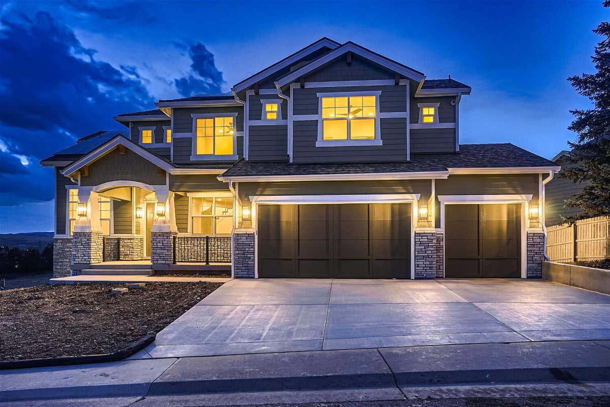 Exterior front Low-light view of a custom home with elegant lights and a paved pathway by Sheffield Homes, Superior, CO