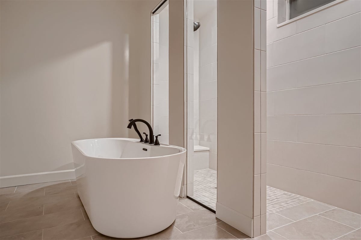 Freestanding bathtub with faucet fixture in a modern bathroom of a custom home by Sheffield Homes in Superior, CO