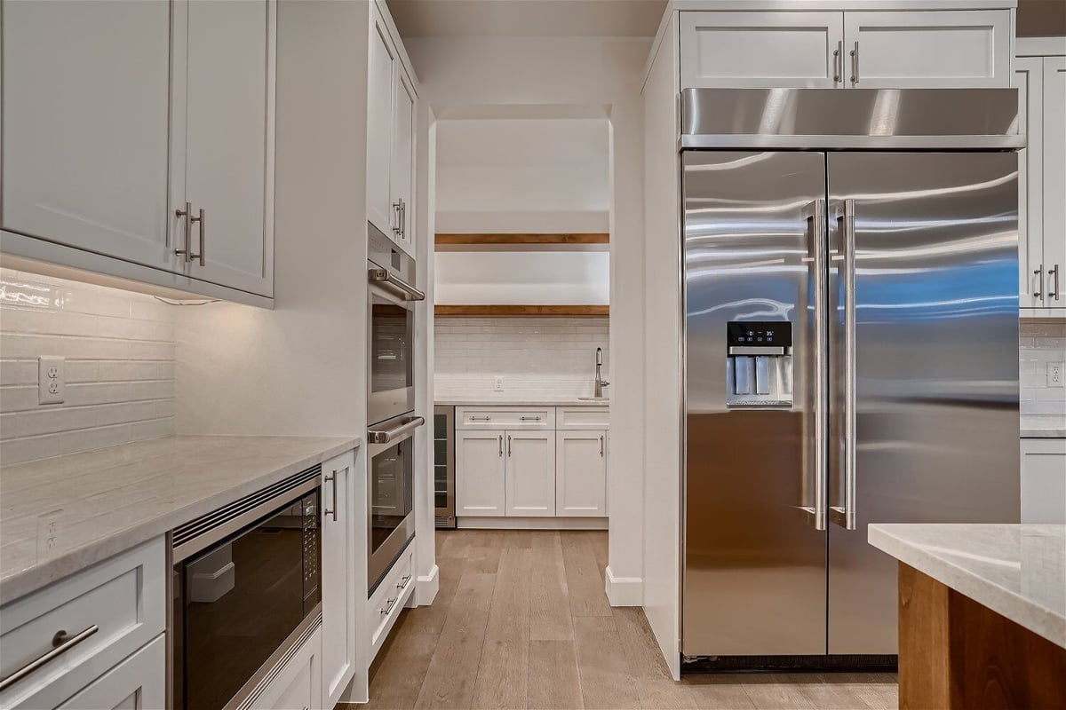 Kitchen details featuring stainless steel appliances and sleek white cabinetry in a Sheffield Homes home in Superior, CO