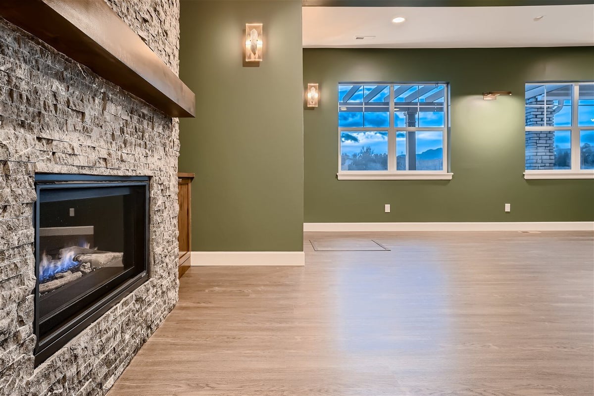 Lower-level living room featuring a custom-designed wall with a mounted fireplace in a Sheffield Homes home in Superior, CO