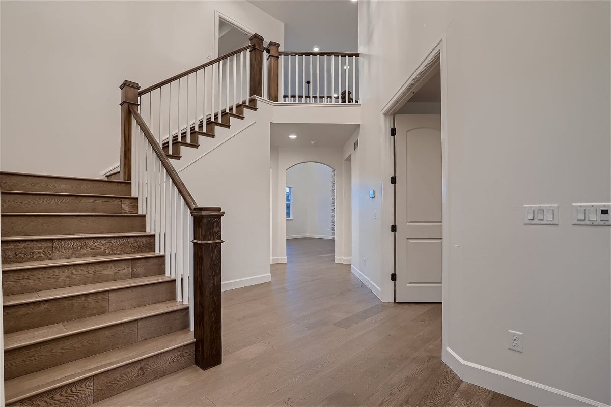 Main stairway landing in the living room with wooden textured steps and railings in a Sheffield Homes home in Superior, CO