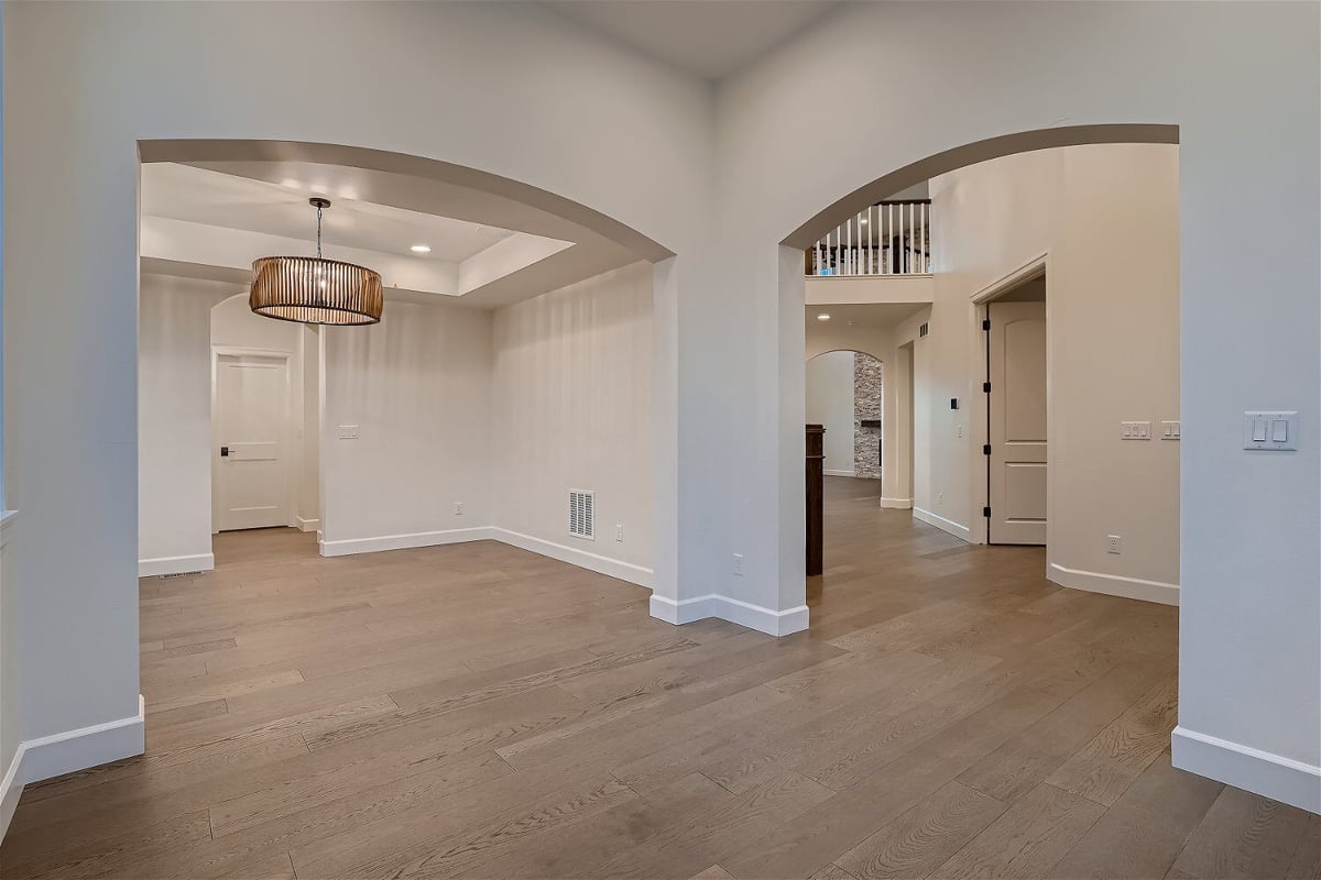 Modern dining room with an elegant light fixture and sliding windows in a custom home by Sheffield Homes in Superior, CO