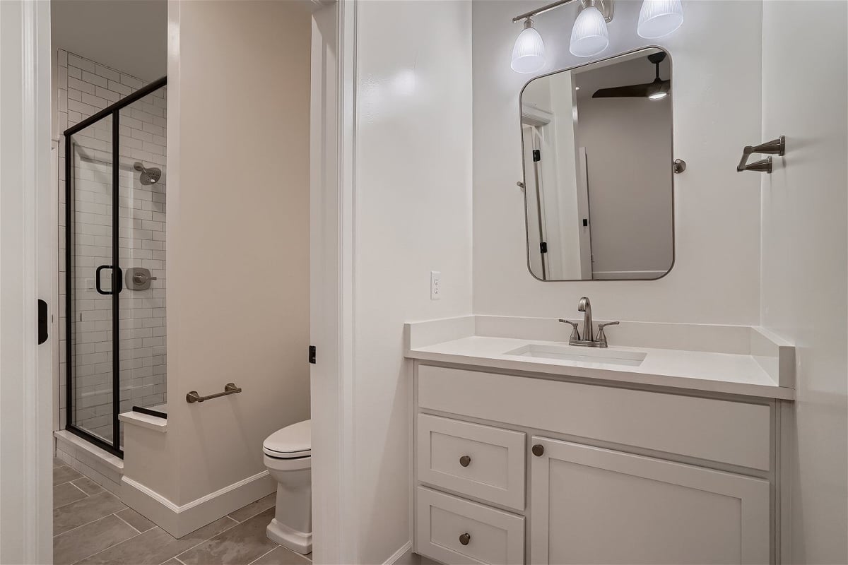 Second-floor Jack and Jill bathroom with a vanity, toilet, and a shower room in a Sheffield Homes home in Superior, CO