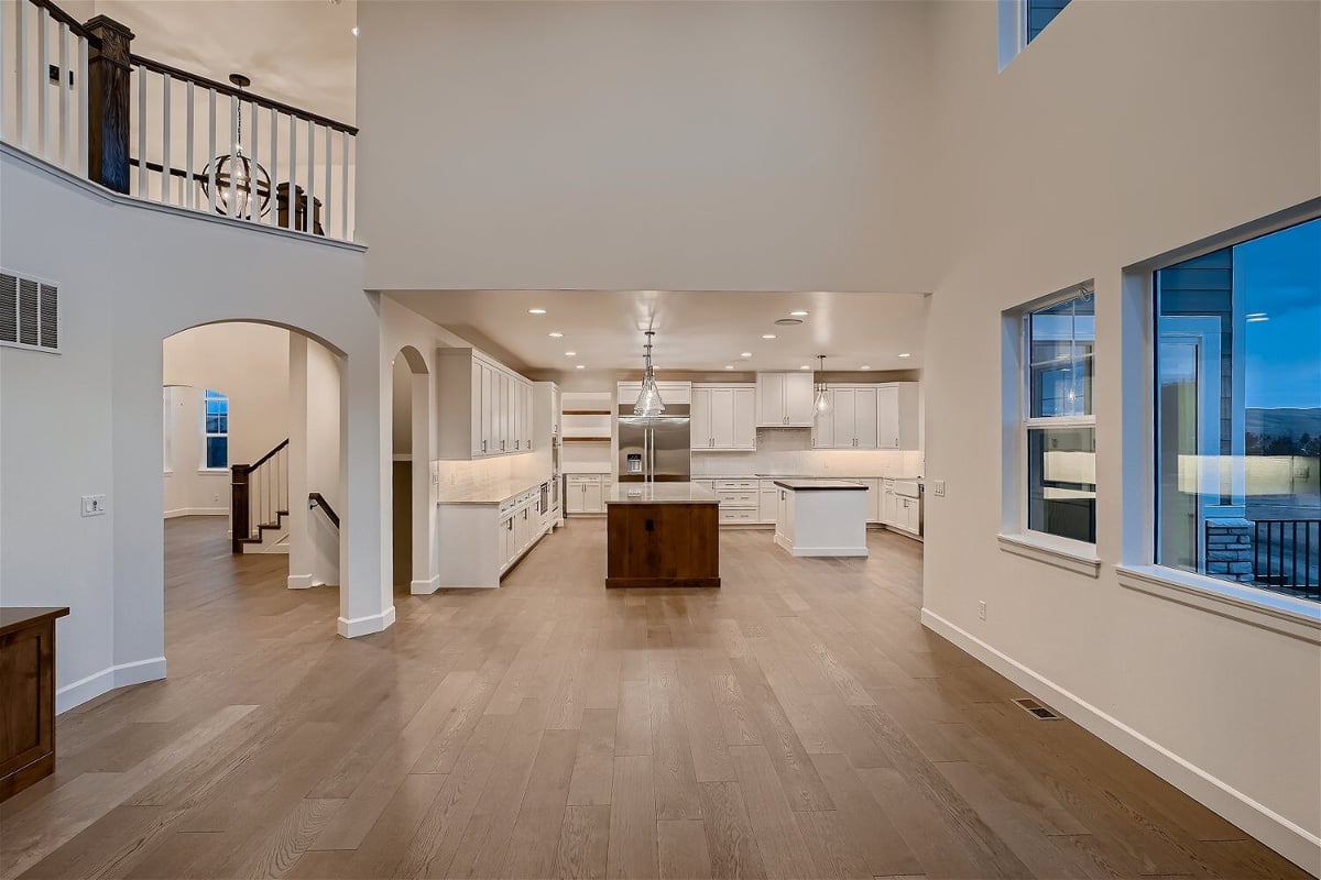 Spacious living room with an open kitchen and a pathway towards the staircase in a Sheffield Homes home in Superior, CO