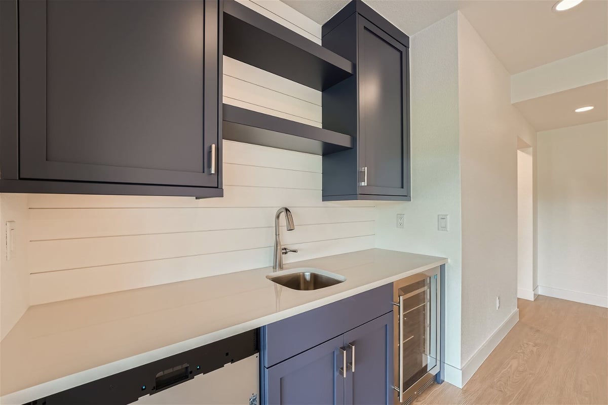 Close-up of a lower-level wetbar with a sink counter and multi-color cabinetry in a Sheffield Homes home in Superior, CO