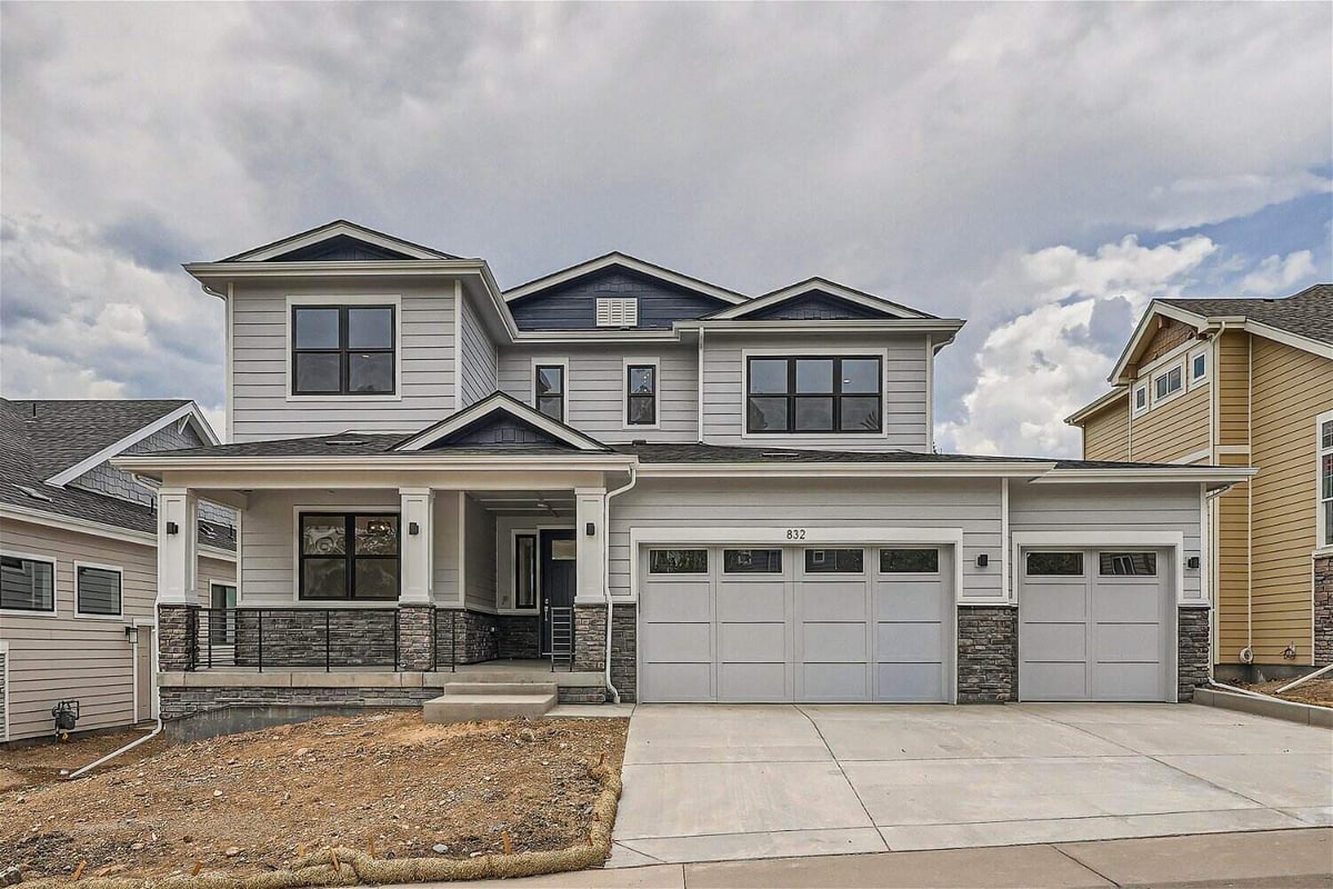 Daylight exterior front view of a custom home with an outdoor yard and a garage by Sheffield Homes in Superior, CO