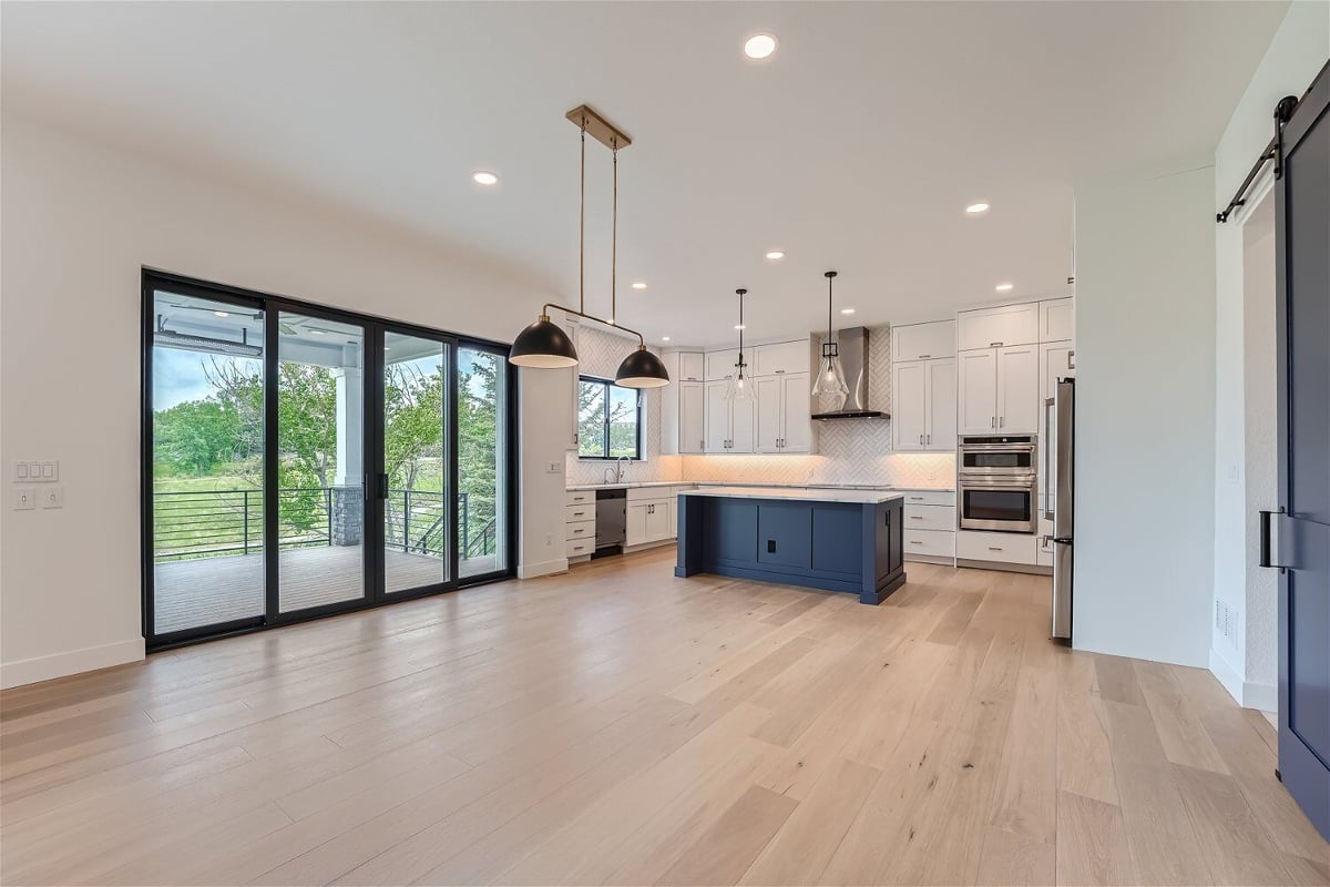 Dining room with sliding doors, wood texture flooring, and a modern open kitchen in a Sheffield Homes home in Superior, CO