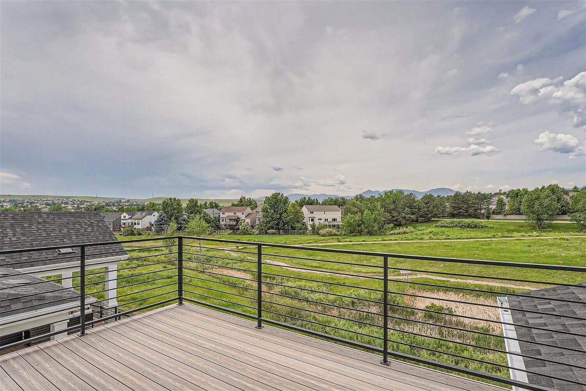 Private balcony off the bedroom with a metal fence, offering expansive greenery views, by Sheffield Homes in Superior, CO