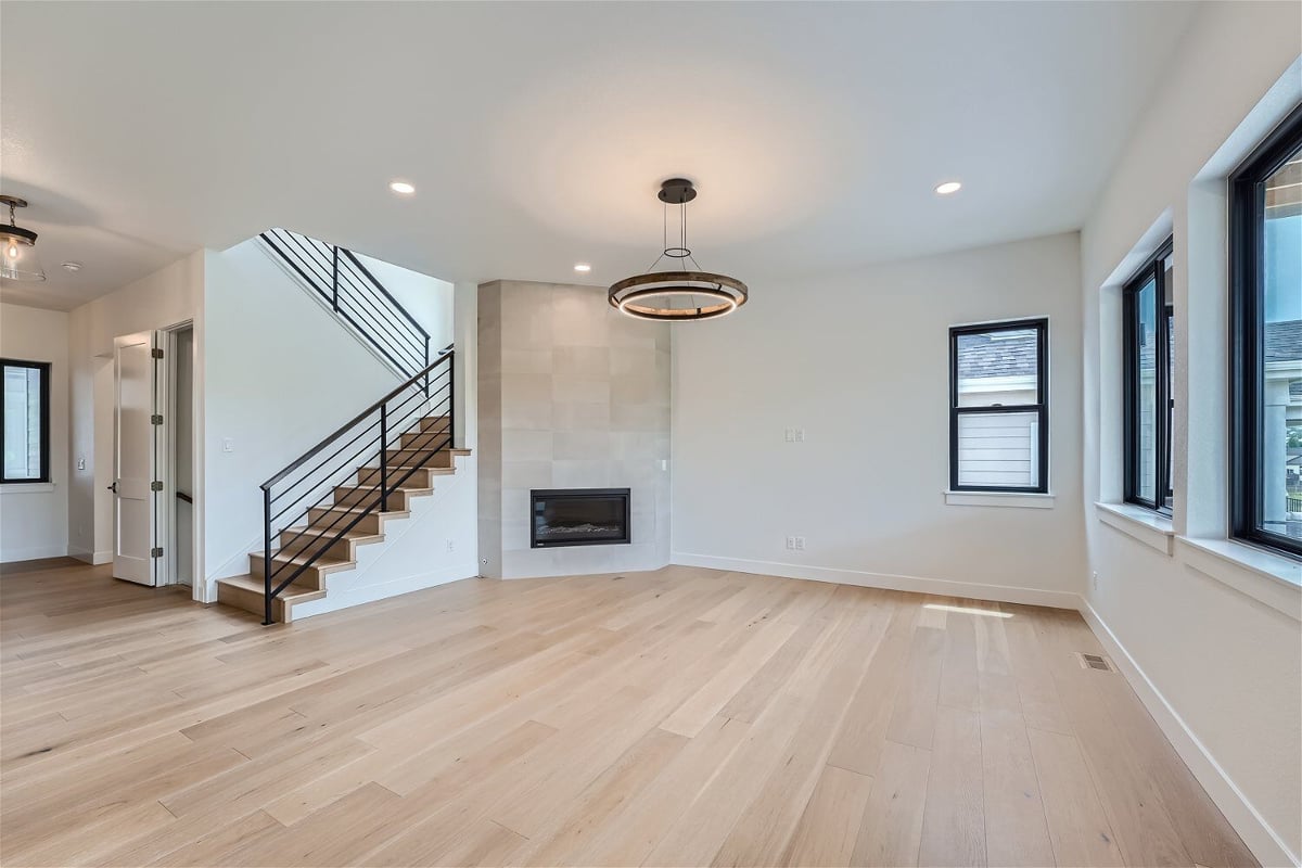 Spacious living room featuring a chandelier, stairway, and sliding windows in a Sheffield Homes home in Superior, CO