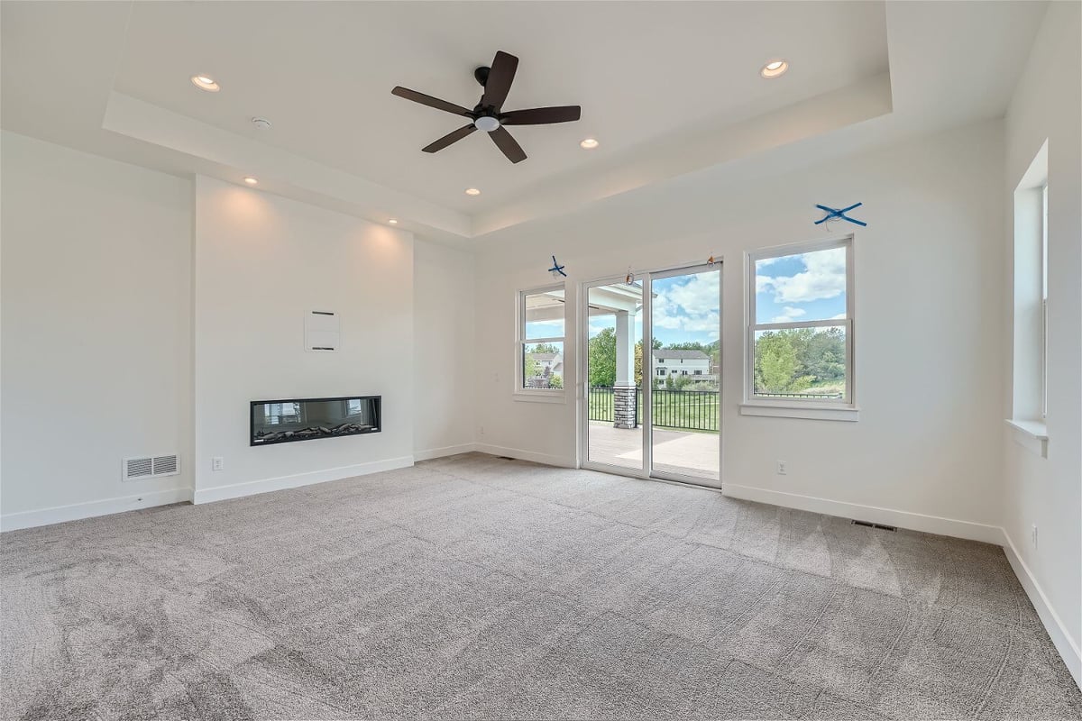 Bedroom with carpet flooring, a fireplace, and a main door leading to the balcony in a Sheffield Homes home in Superior, CO