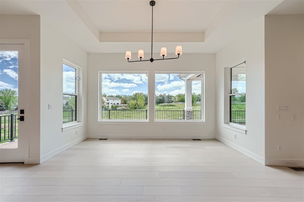 Dining room with an elegant chandelier and large windows offering outside views in a Sheffield Homes home in Superior, CO