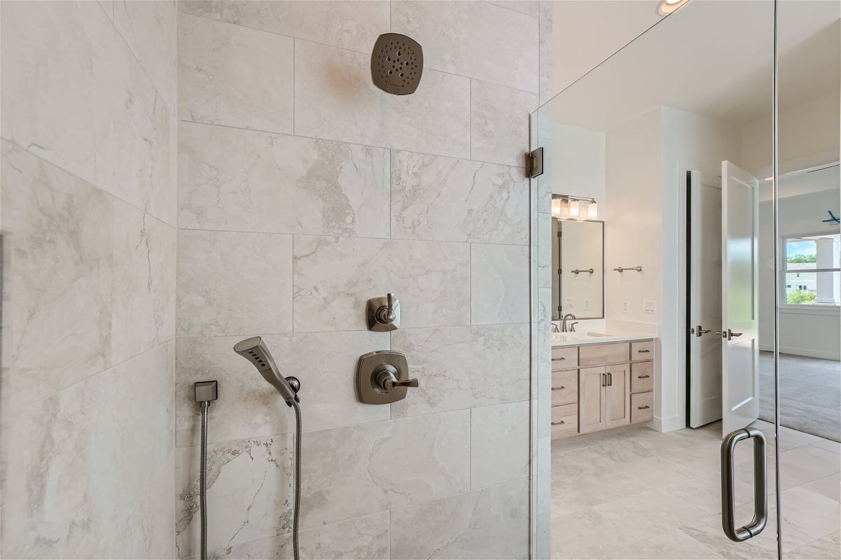 Inside the glass-enclosed shower room with shower fixtures in a bathroom of a Sheffield Homes home in Superior, CO
