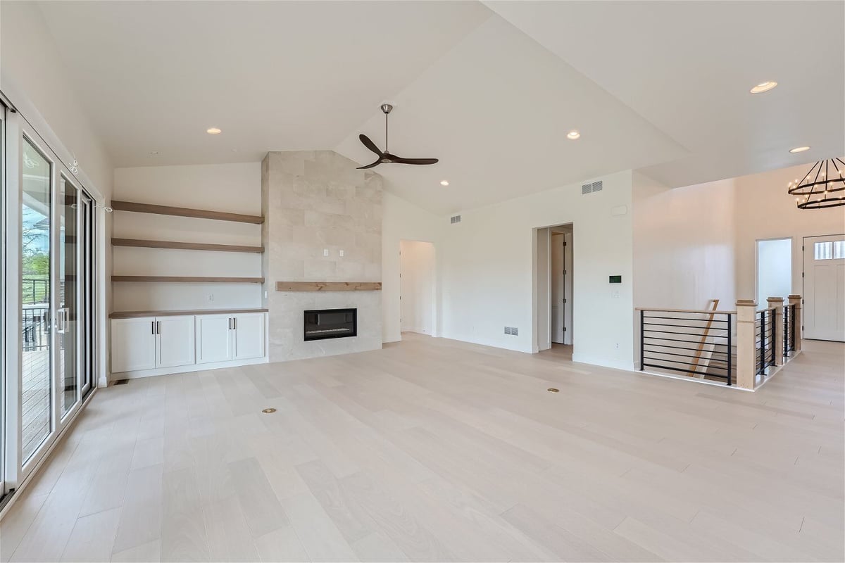 Living room with a corner fireplace, wall-mounted cabinetry, and access doors in a Sheffield Homes home in Superior, CO