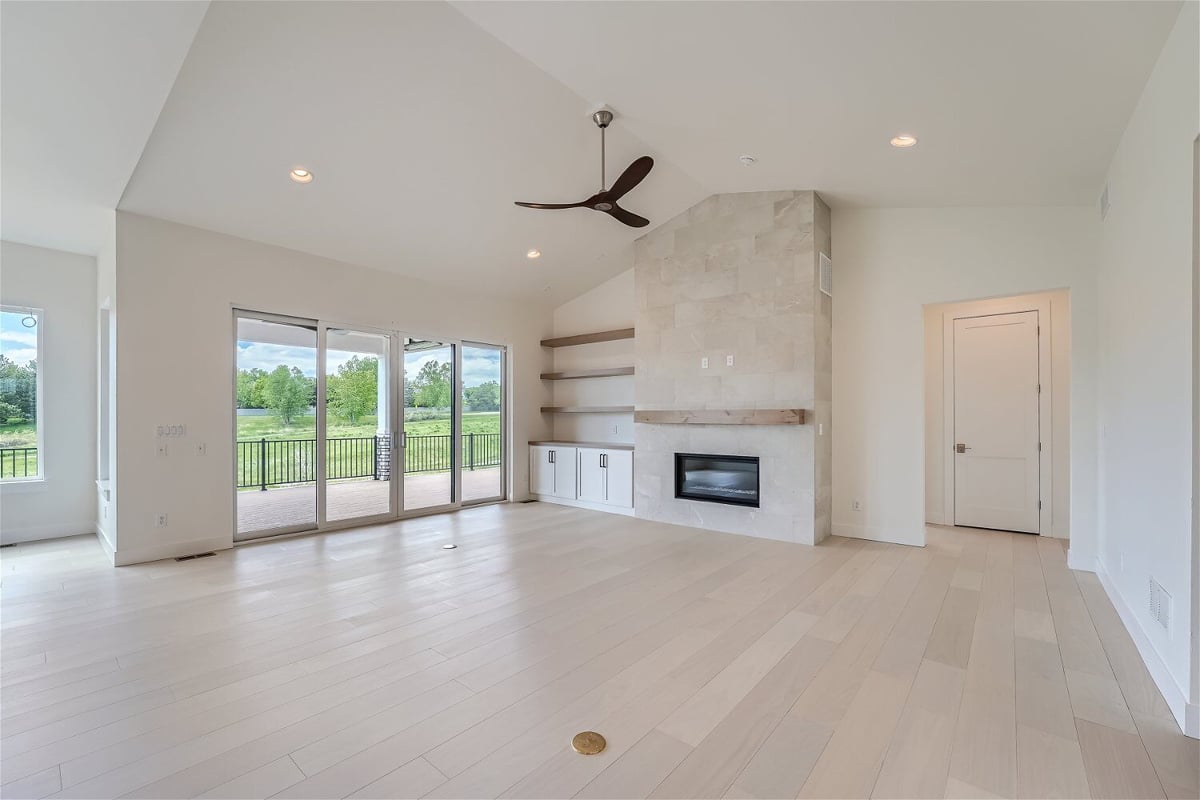 Living room with a corner fireplace, wall-mounted cabinetry, and sliding doors in a Sheffield Homes home in Superior, CO