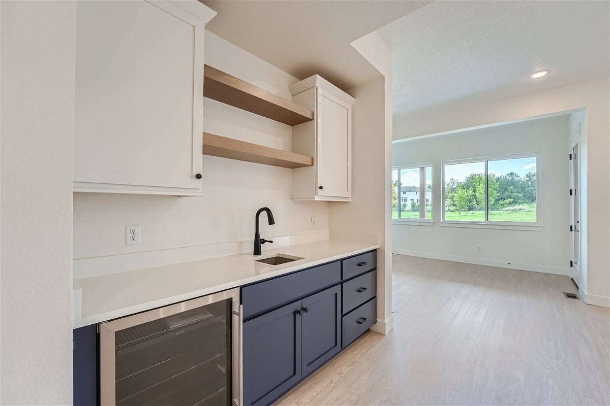 Lower-level wetbar detailing with a sink faucet, base cabinets, and wall cabinetry in a Sheffield Homes home in Superior, CO