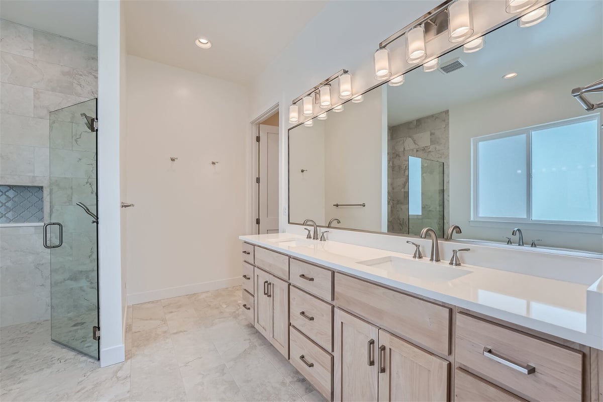 Primary bathroom with a large vanity featuring dual faucets and a large mirror in a Sheffield Homes home in Superior, CO