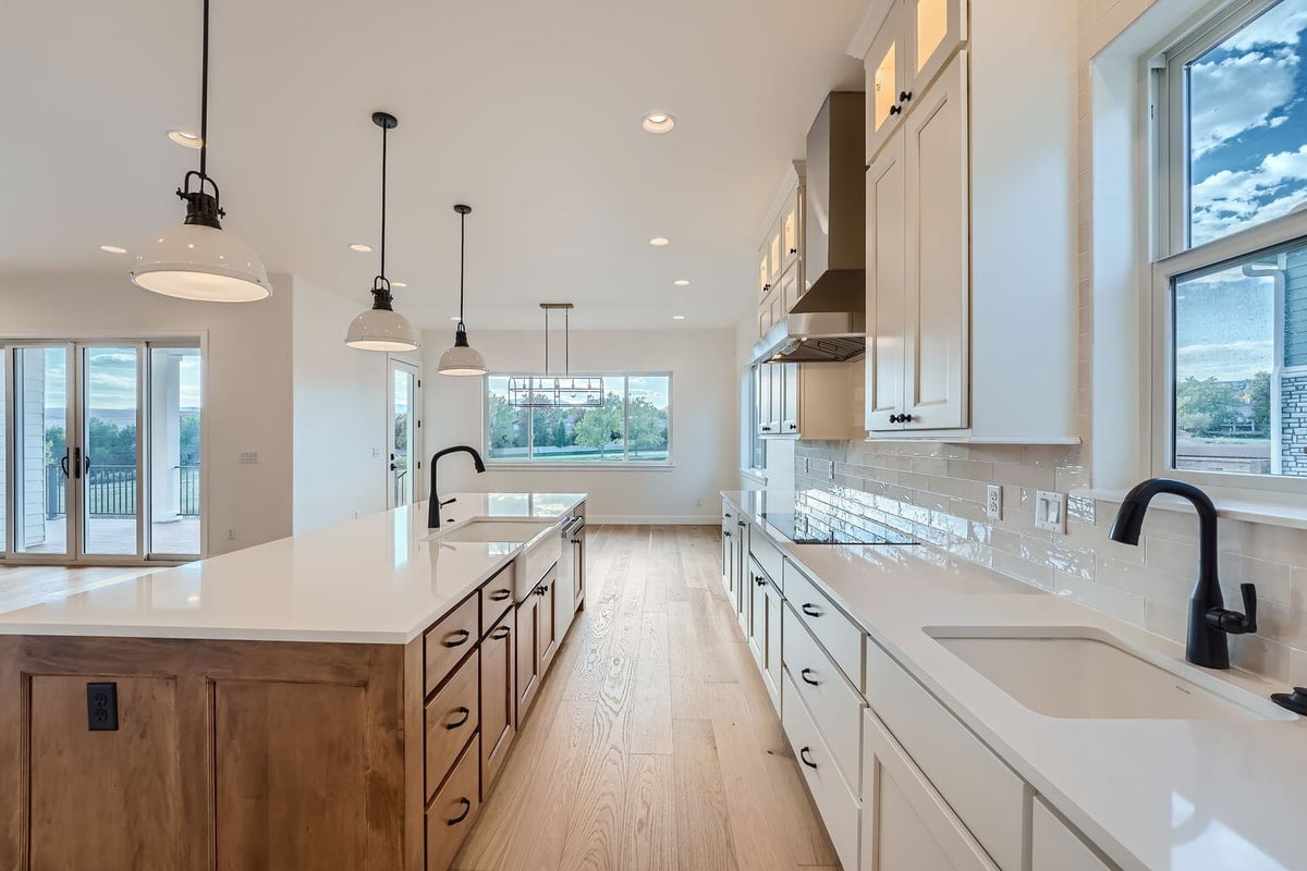 Alternate view of the kitchen in a custom Denver home by Sheffield Homes, showcasing the island and cabinetry