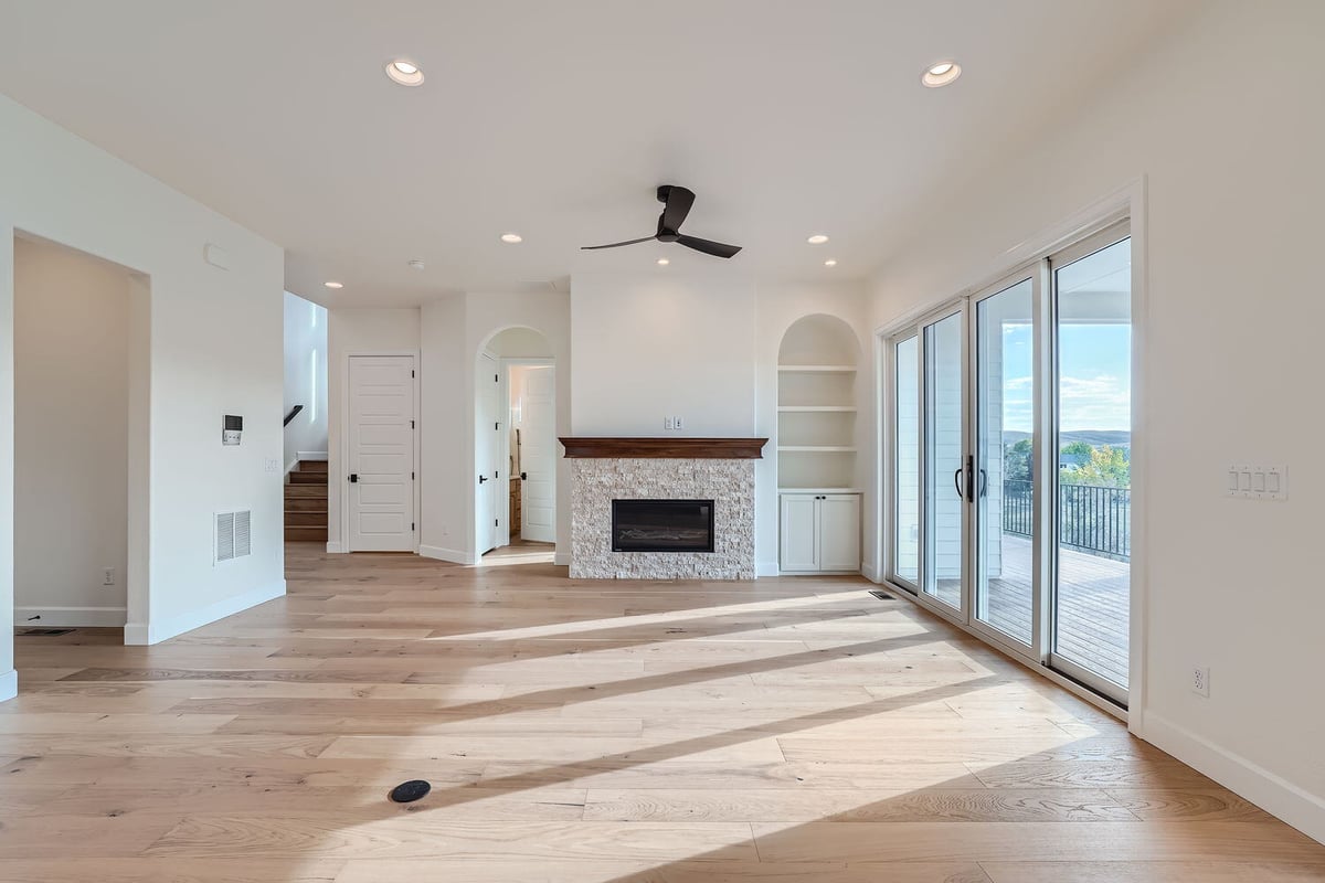 Corner view of a living room in a custom home by Sheffield Homes in Denver, CO, featuring wood floors and large doors