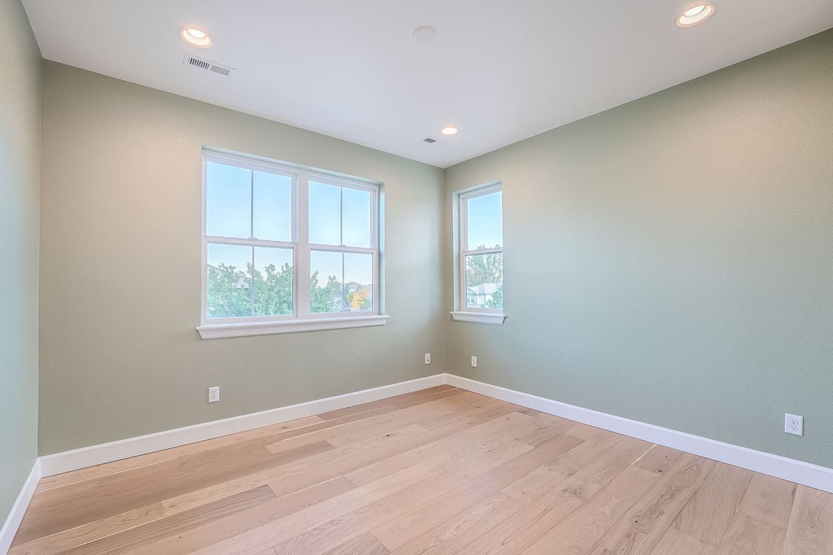 Cozy bedroom with soft green walls and large windows, Sheffield Homes, Denver, CO