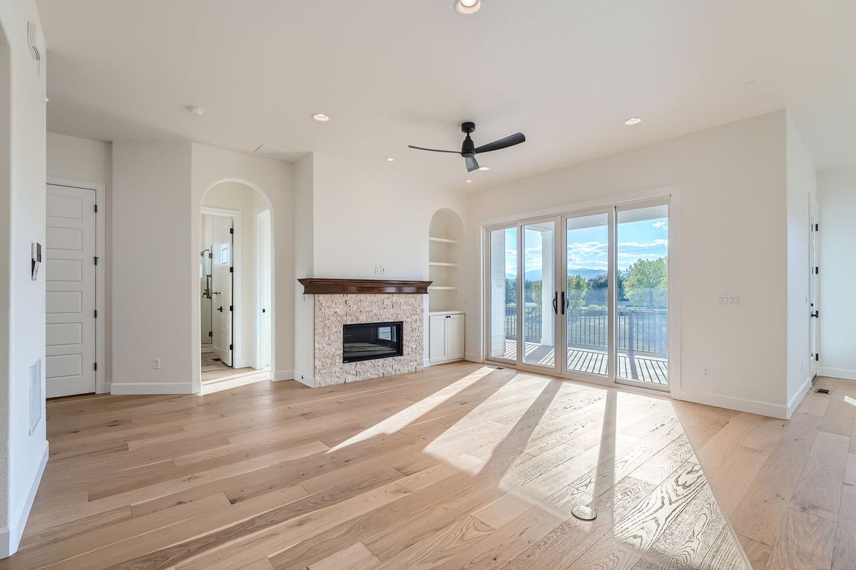 Cozy living room in a Sheffield Homes custom home in Denver, CO, featuring a built-in fireplace and ample sunlight